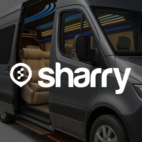 logo i nazwa firmy Sharry na tle szarego mikrobusu, w którym widać fotel typu recliner